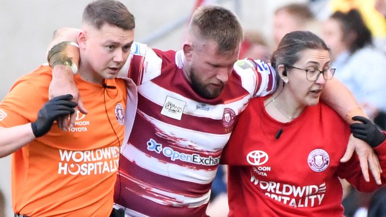 Mike Cooper is helped from the field during Wigan's win over St Helens