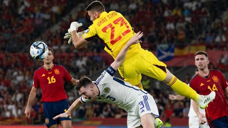 Spain&#39;s Unai Simon collides with Scotland&#39;s Andy Robertson 