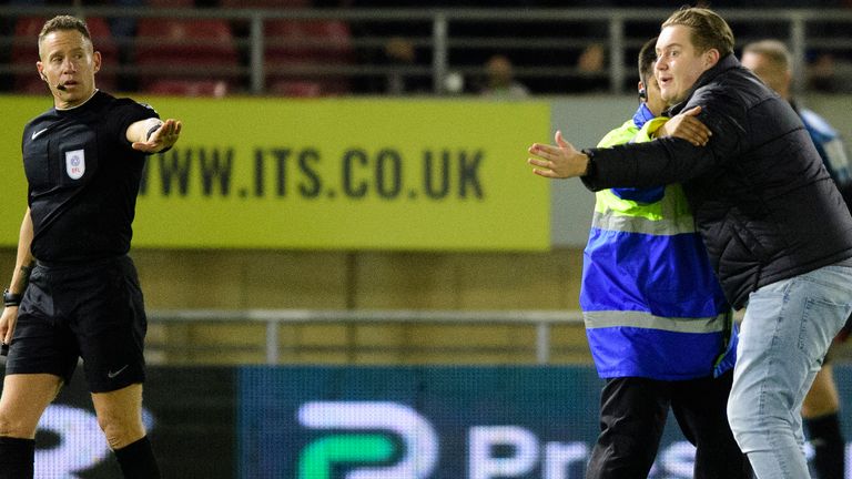 A Leyton Orient fan enters the pitch to try and get referee Stephen Martin to stop the match against Lincoln City                                                                       