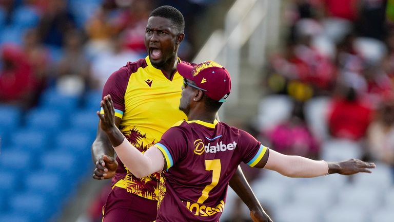 West Indies&#39; Jason Holder..celebrates with Akeal Hosein..taking the wicket of England&#39;s captain Jos Buttler during the fifth T20 cricket match at Brian Lara Stadium in Tarouba, Trinidad and Tobago, Thursday, Dec. 21, 2023. (AP Photo/Ricardo Mazalan)