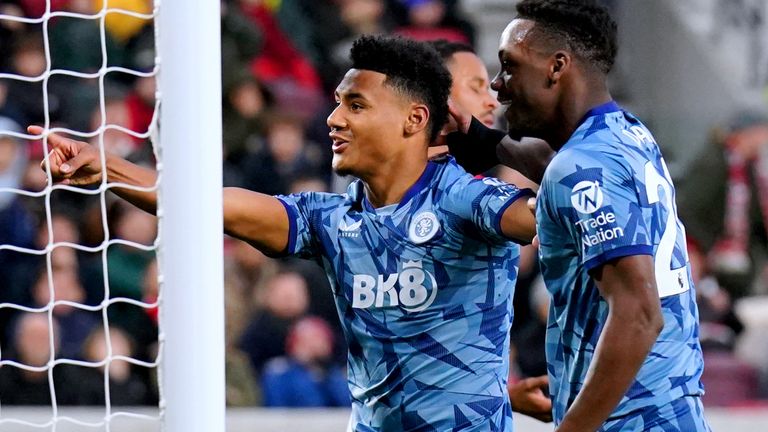 Ollie Watkins gestures toward the Brentford supporters behind the goal