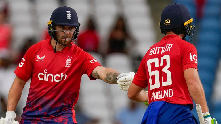 England&#39;s Phil Salt..celebrates with captain Jos Buttler after scoring fifty runs during the bowling of West Indies&#39; Andre Russell, left, during the fourth T20 cricket match at Brian Lara Stadium in Tarouba, Trinidad and Tobago, Tuesday, Dec. 19, 2023. (AP Photo/Ricardo Mazalan)