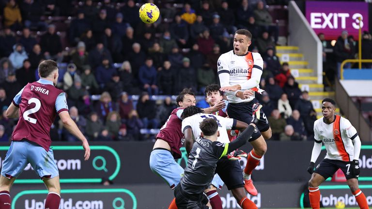 Carlton Morris heads in Luton&#39;s equaliser as Burnley goalkeeper James Trafford is blocked off by Elijah Adebayo