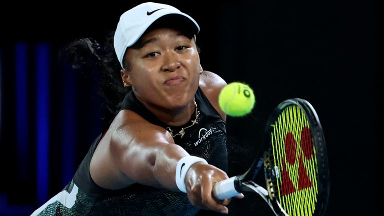 Naomi Osaka of Japan plays a backhand return to Caroline Garcia of France during their first round match at the Australian Open tennis championships at Melbourne Park, Melbourne, Australia, Monday, Jan. 15, 2024. (AP Photo/Asanka Brendon Ratnayake)