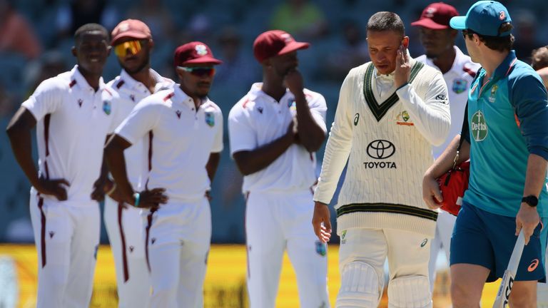 Australia&#39;s Usman Khawaja, third right, is escorted off the field after he was struck by a delivery from West Indies&#39; Shamar Joseph on the third day of their cricket test match in Adelaide, Australia, Friday, Jan. 19, 2024. (AP Photo/James Elsby)