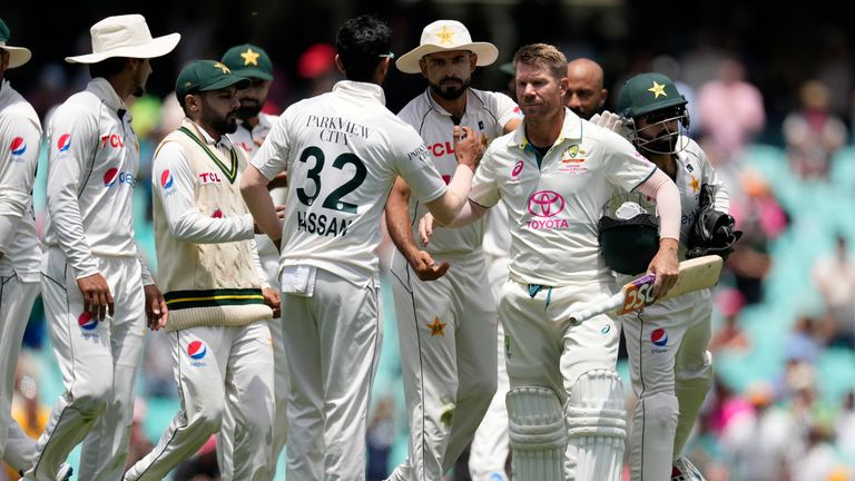 Australia&#39;s David Warner, third right, is congratulated by Pakistan&#39;s players as he walks off the field on the fourth day of their cricket test match in Sydney