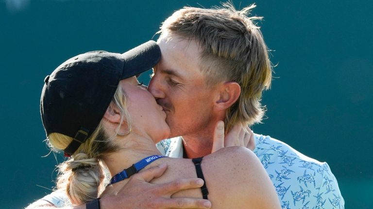 Jake Knapp, of the United States, kisses his girlfriend Makena White after winning the Mexico Open golf tournament in Puerto Vallarta, Mexico, Sunday, Feb. 25, 2024. (AP Photo/Fernando Llano)