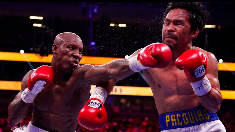 Yordenis Ugas, left, of Cuba, hits Manny Pacquiao, of the Philippines,  in a welterweight championship boxing match Saturday, Aug. 21, 2021, in Las Vegas. (AP Photo/John Locher)