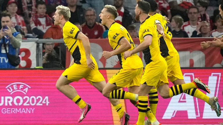 Dortmund's Julian Ryerson, left, celebrates after scoring his side's second goal during the German Bundesliga soccer match between FC Bayern Munich and Borussia Dortmund at the Allianz Arena stadium, in Munich, Germany, Saturday, March 30, 2024. (AP Photo/Matthias Schrader)