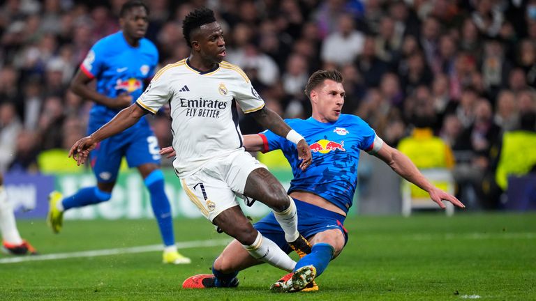 Real Madrid's Vinicius Junior, left, scores his side's opening goal during the Champions League round of 16 second leg soccer match between Real Madrid and RB Leipzig at the Santiago Bernabeu stadium in Madrid, Spain, Wednesday, March 6, 2024. (AP Photo/Manu Fernandez)