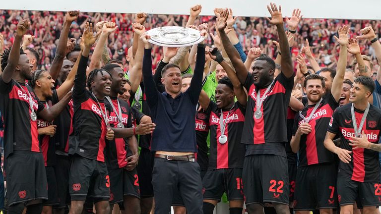 Xabi Alonso lifts the Bundesliga trophy after an unbeaten season