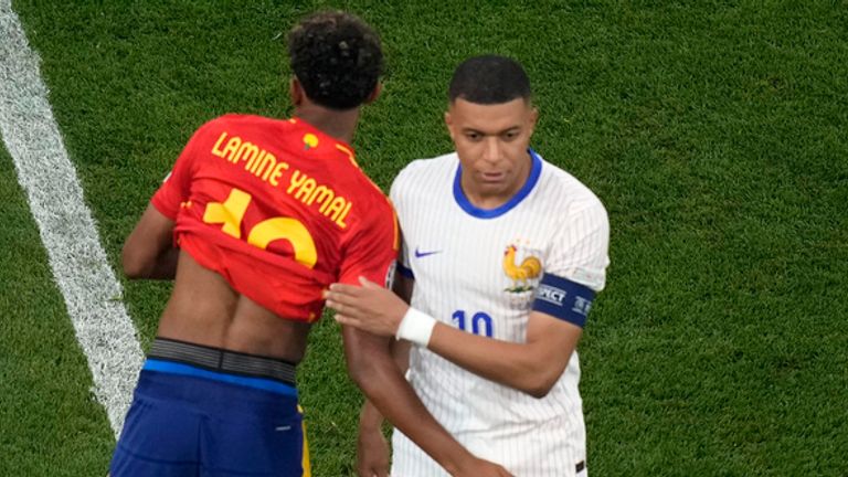 Spain's Lamine Yamal embraces Kylian Mbappe of France ahead of a semifinal match between Spain and France at the Euro 2024 soccer tournament in Munich, Germany, Tuesday, July 9, 2024. (AP Photo/Ariel Schalit)