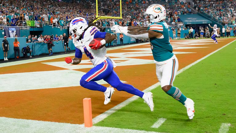 Buffalo Bills running back James Cook (4) runs with the ball past Miami Dolphins safety Jevon Holland (8) to score a touchdown during an NFL football game, Thursday, Sept. 12, 2024, in Miami Gardens, Fla. (AP Photo/Doug Murray)